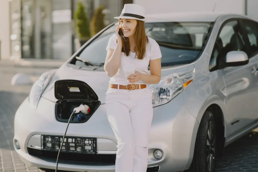 Persona esperando que recargue el auto para Movilidad Sostenible en países fuera de Ecuador